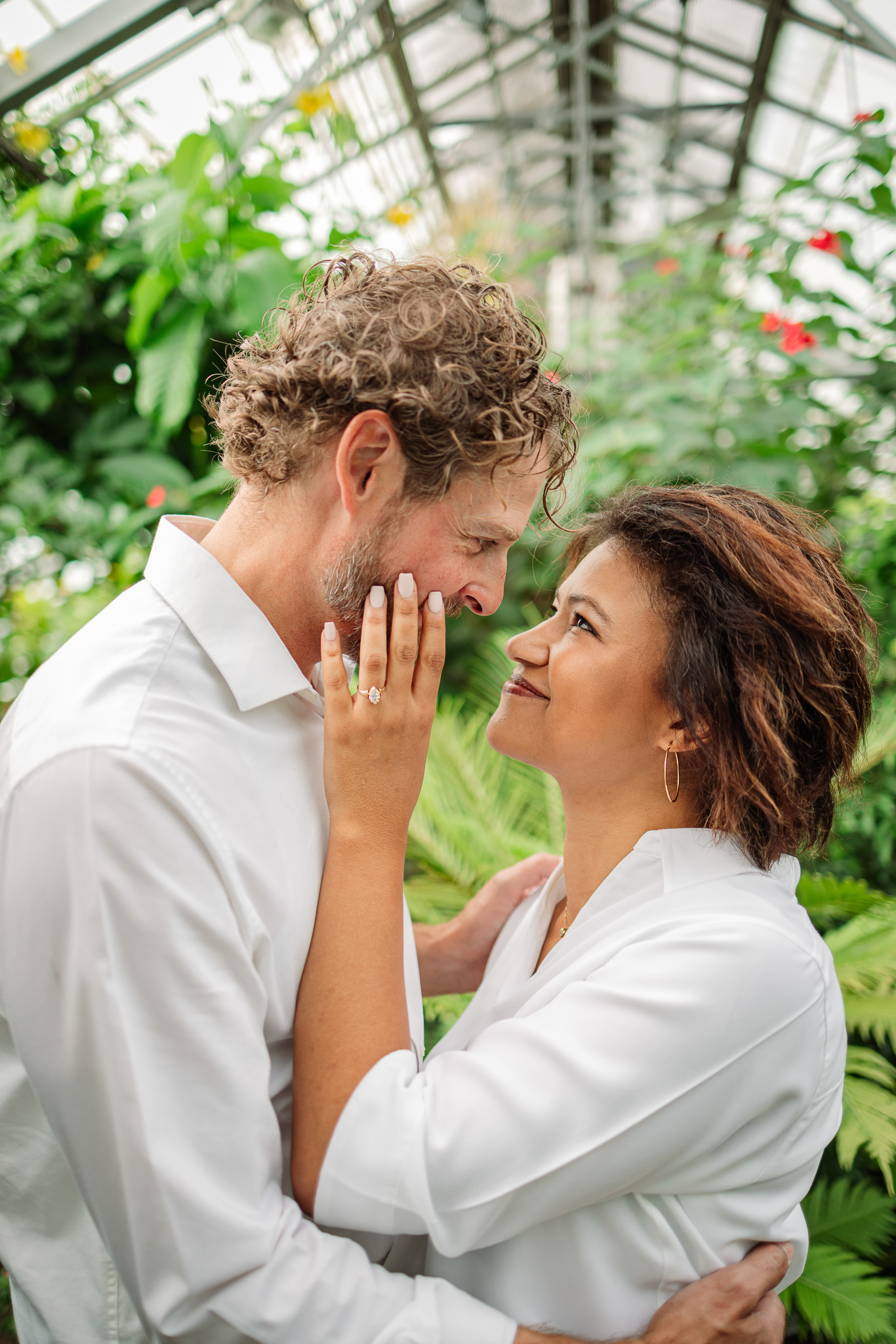 Close-up romantic engagement portrait at Allan Gardens Toronto with couple sharing intimate moment inside greenhouse.